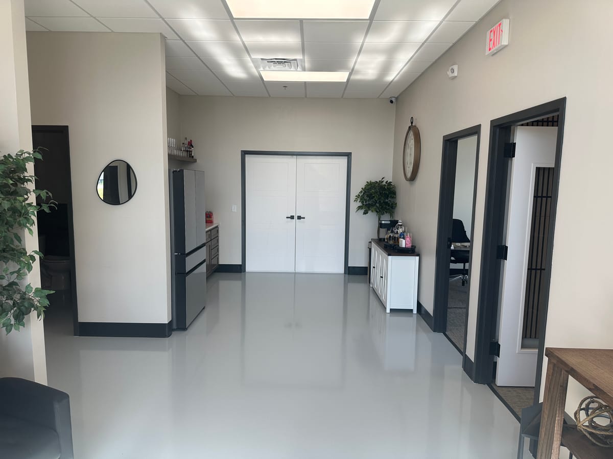 Finished commercial corridor with new flooring, doors, and hardware installed by JAKS Construction