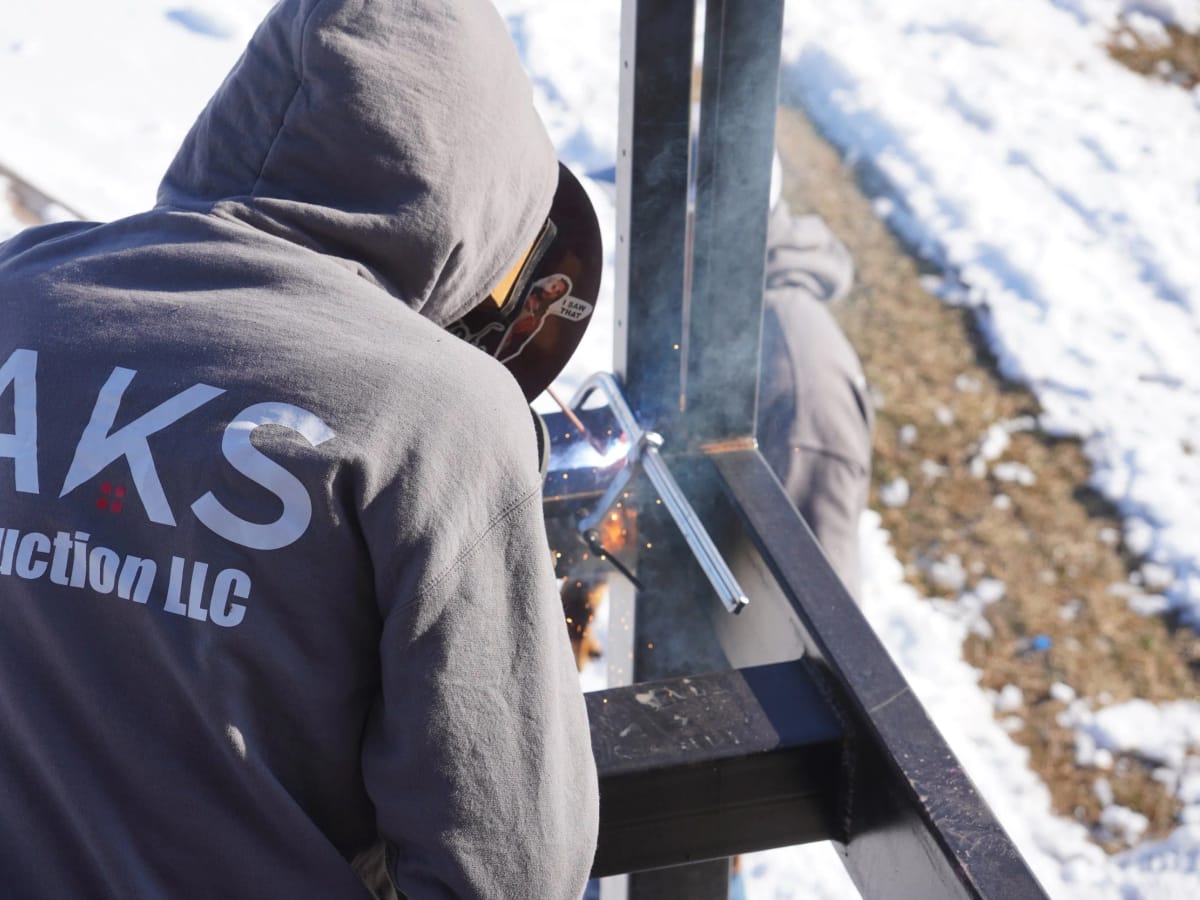 A JAKS Construction welder joining structural steel on a job site