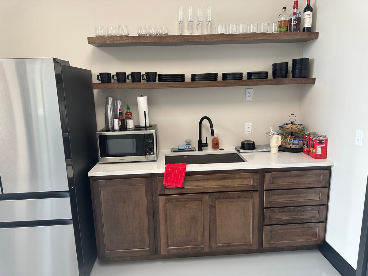 Finished breakroom cabinetry and floating shelves built by JAKS Construction for Walk Your Plans Wichita