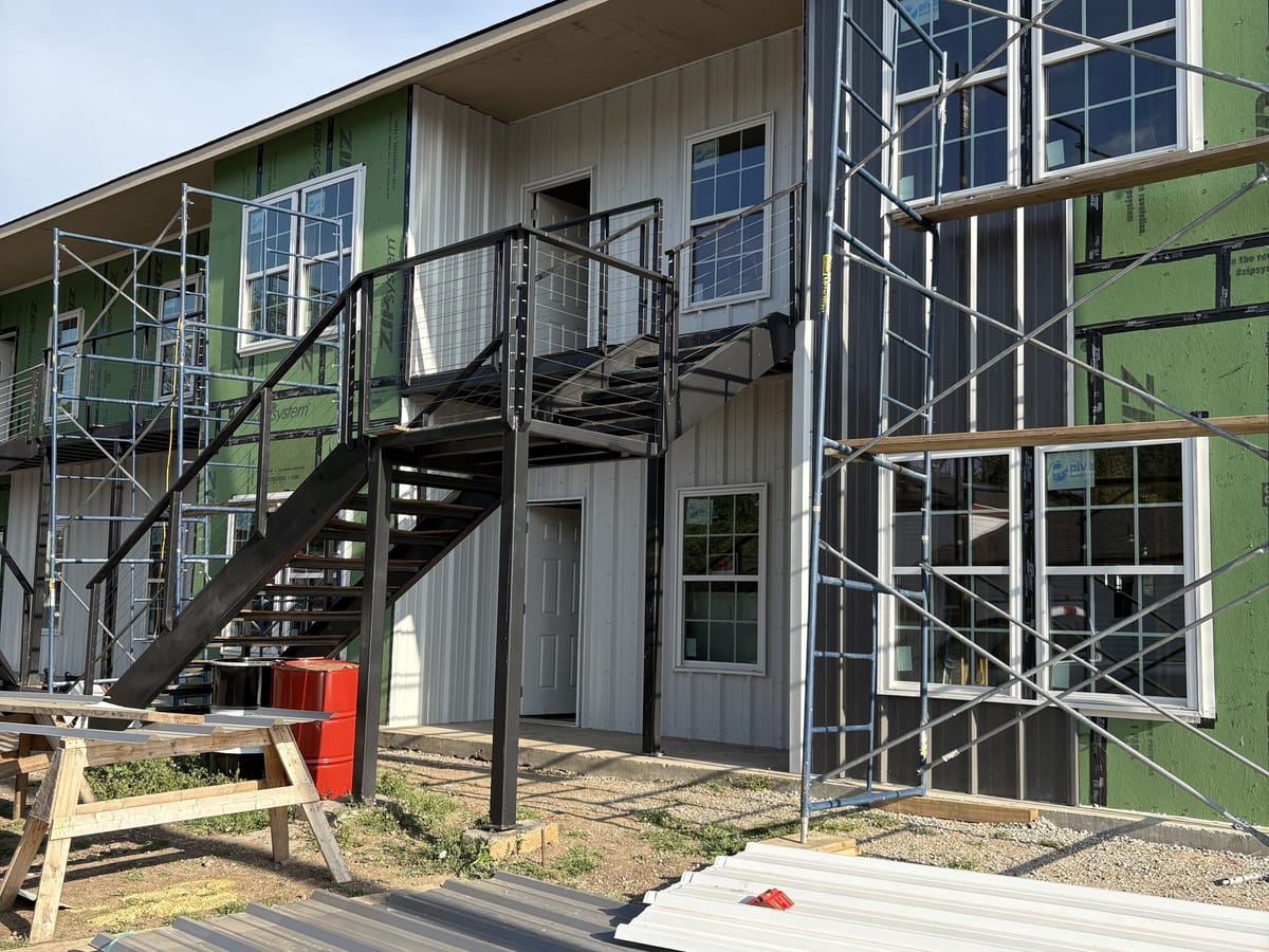 A JAKS Construction multifamily building under construction with scaffolding in place