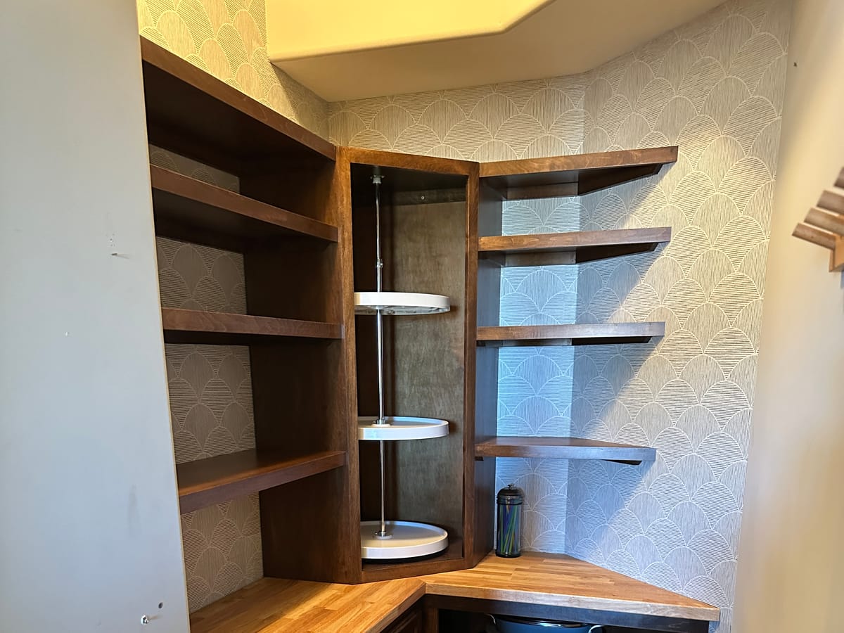 Custom stained pantry shelving and rotating corner unit built by JAKS Construction in Andover, Kansas