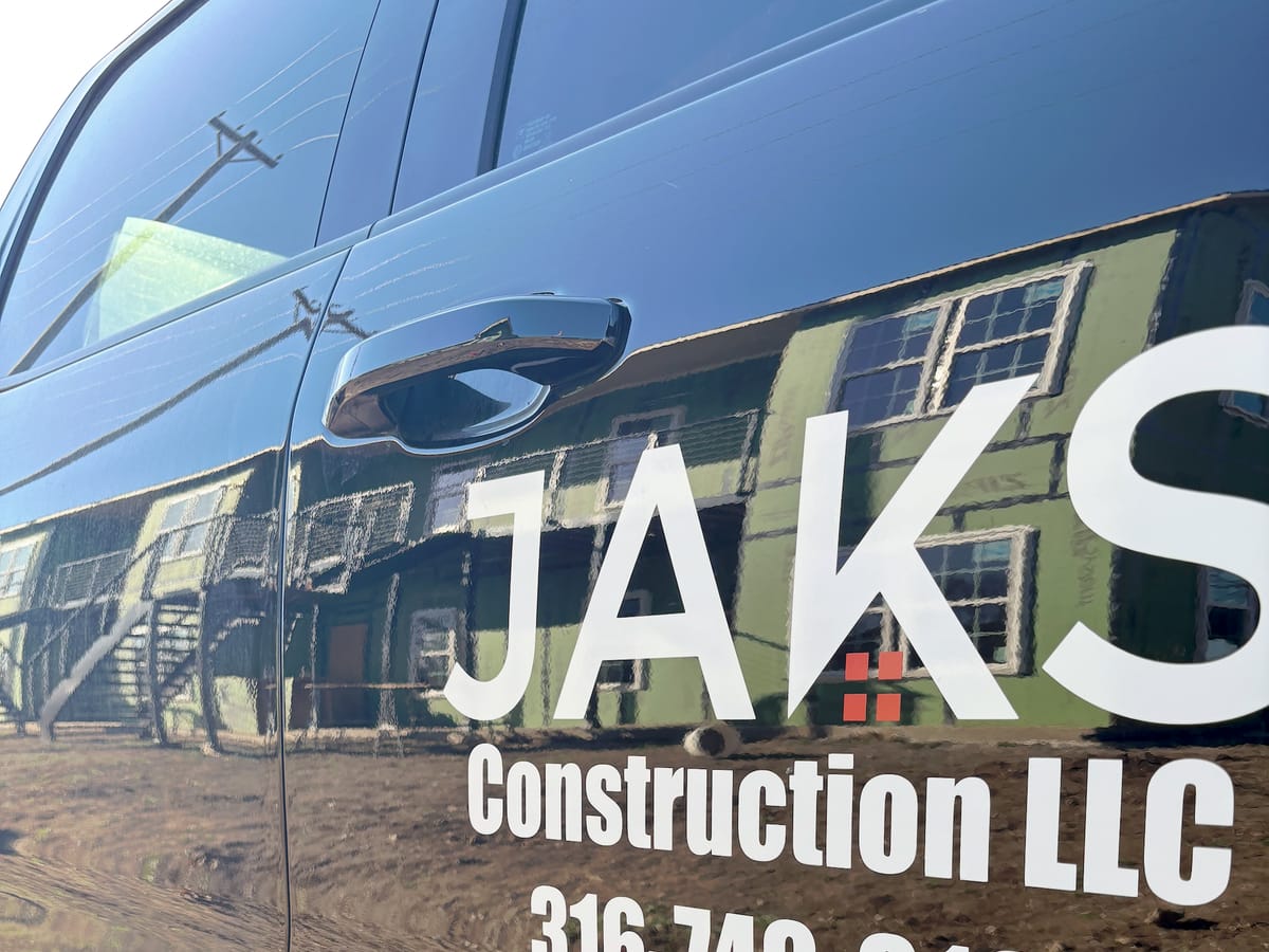 A six-plex under construction by JAKS Construction, reflected in the side of a JAKS truck